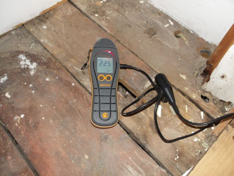 Damp survey device measuring moisture levels on wooden flooring in Chester.