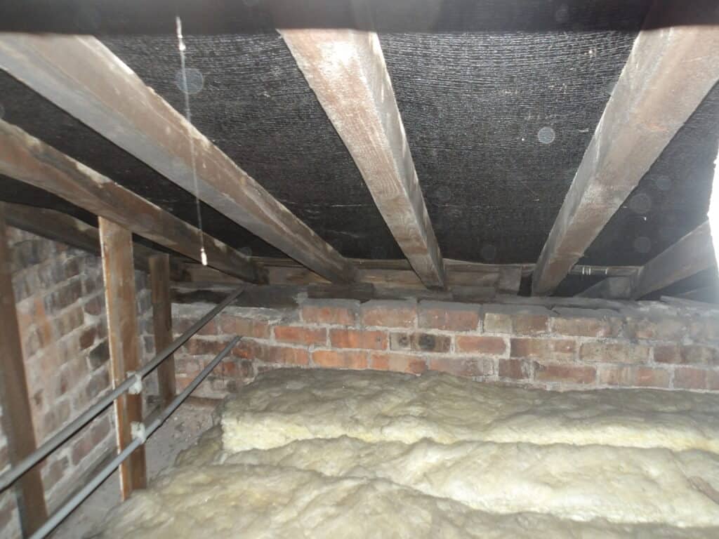 Loft space with wooden beams and insulation for roof insulation.